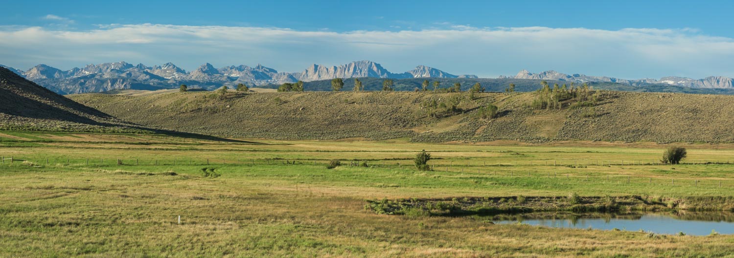 Ground-level panorama of meadow, pond, and the Wind River Range